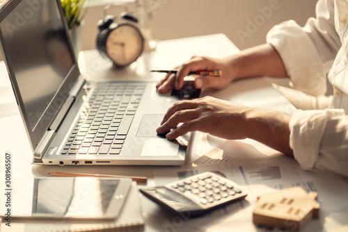 Hand of Business people calculating interest, taxes and profits to invest in real estate and home buying