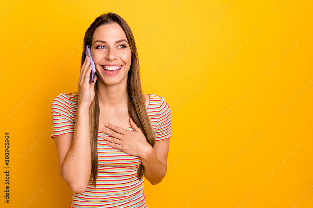 Photo of attractive pretty lady hold telephone hands speaking with best friend listen funny jokes gossips rumors wear casual striped t-shirt isolated yellow color background Photo of attractive pretty lady hold telephone hands speaking with best friend listen funny jokes gossips rumors wear casual striped t-shirt isolated yellow color background