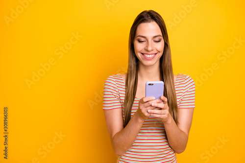 I love you. Photo of funny pretty lady hold telephone hands reading handsome guy sms love confession wear casual striped t-shirt isolated yellow color background