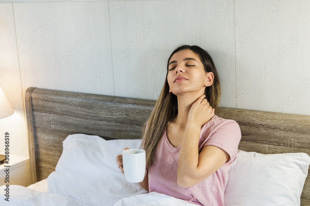 Woman sitting on bed drinking coffee smiling Woman sitting on bed drinking coffee smiling
