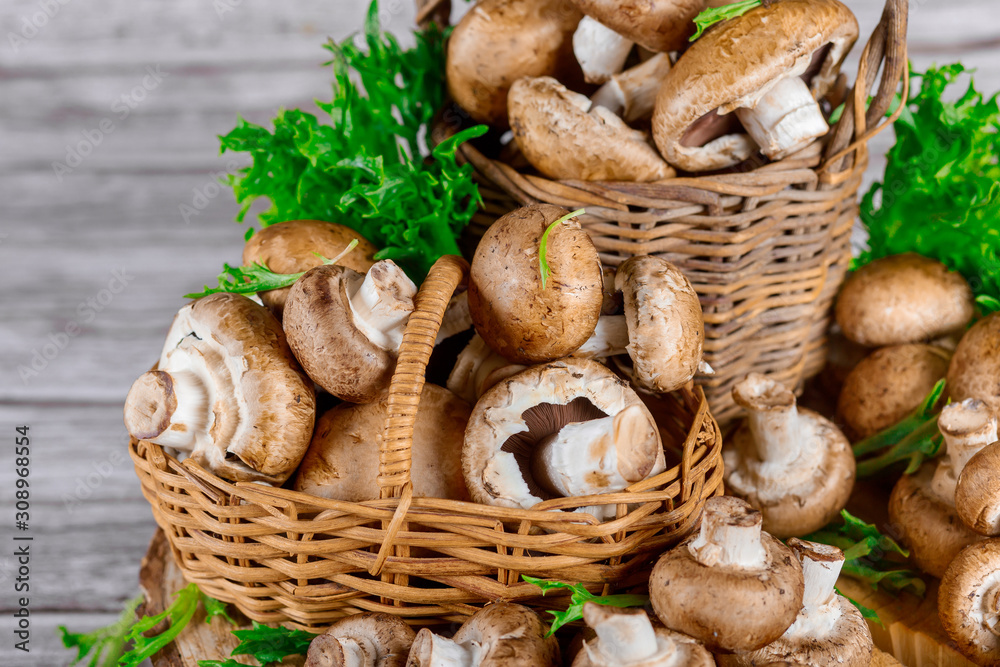 Portobello champignons in a wicker baskets on a wooden table.