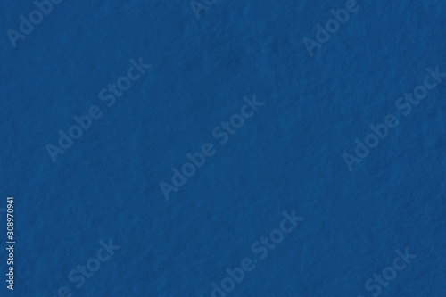 Texture of fresh snow colored in classic blue color of the year 2020. Main pantone color trend, winter holidays concept. Modern luxury classic blue background or mock up with space for text