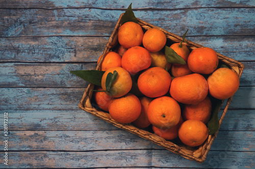wooden basket with tangerines isolated on background