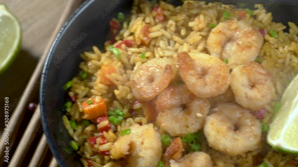 Fried Rice with fresh shrimp, rice, green onions, vegetables and lime in a bowl. Healthy Thai food isolated on white background. Camera close-up panning. Fried Rice with fresh shrimp, rice, green onions, vegetables and lime in a bowl. Healthy Thai food isolated on white background. Camera close-up panning.