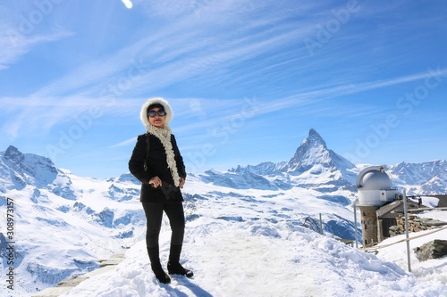 Asian woman traveler posing with mountain Matternhorn in winter season and clear sky