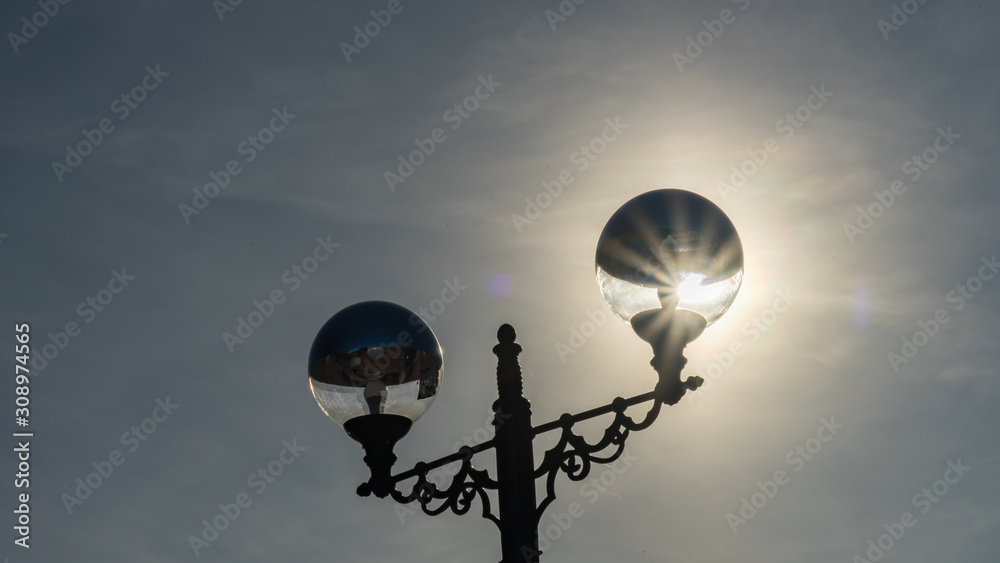 Sunshine behind Street light on the sky background. Sochi, Russia.