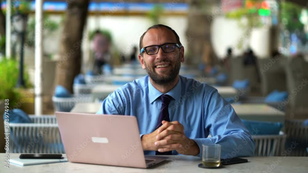 Portrait of happy businessman with laptop sitting in cafe Portrait of happy businessman with laptop sitting in cafe