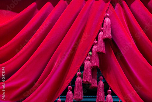 Red velvet curtains with tassels. Close up