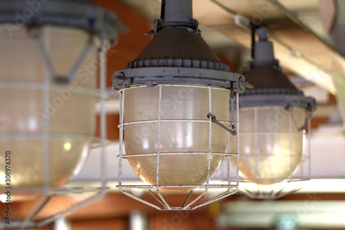 Old industrial pendant lamp. Glass shade in a steel mesh.