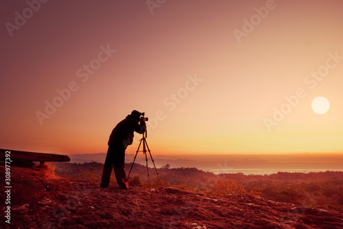 silhouette photographer take photo with sunset or sunrise background