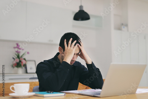 The man are stressed at work in the office. Asian businessman stressful and headache with laptop computer. Young male with headache at office, feeling sick at work.