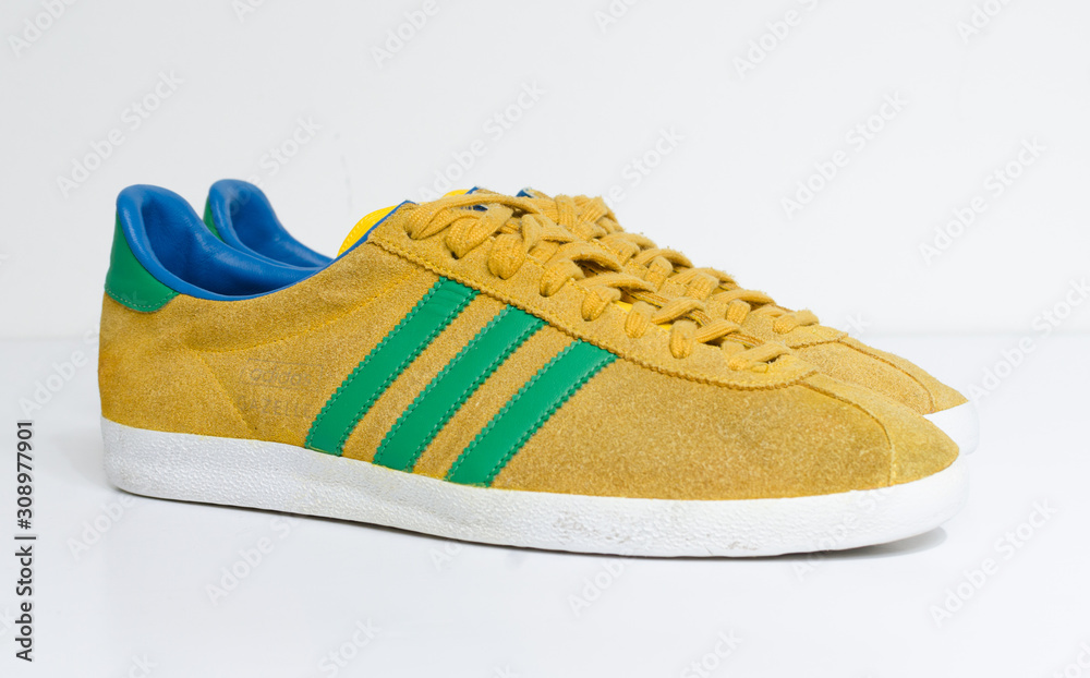 london, england, 05/05/2018 Adidas Gazelle Mustard Gold & Green Stripe  Trainers vintage sneaker trainers. yellow suede adidas trainers, stylish  retro football street fashion. famous three stripes Photos | Adobe Stock