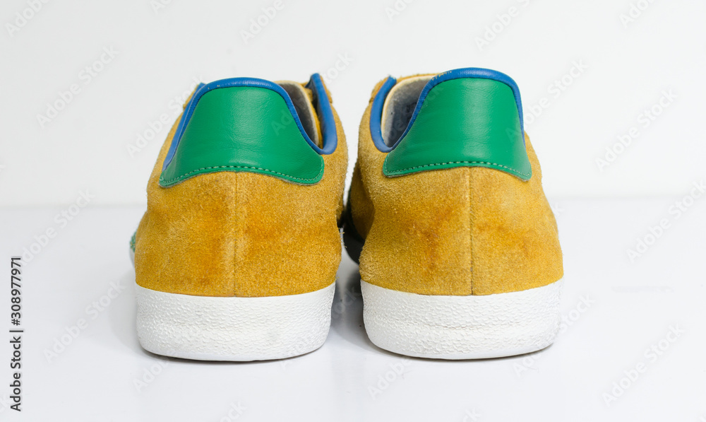 london, england, 05/05/2018 Adidas Gazelle Mustard Gold & Green Stripe  Trainers vintage sneaker trainers. yellow suede adidas trainers, stylish  retro football street fashion. famous three stripes Photos | Adobe Stock