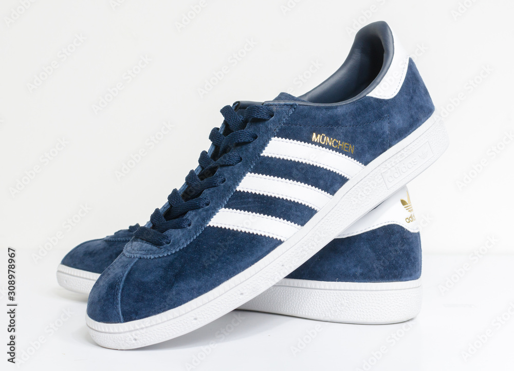 london, england, 05/05/2018 Adidas Munchen gazelle vintage sneaker trainers. Blue suede adidas trainers, stylish retro football fashion. famous three stripes Stock | Adobe Stock