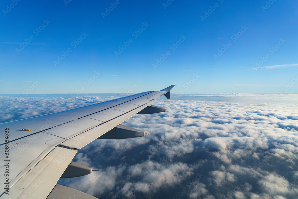 Obraz premium Flugzeug-Flügel über Wolken