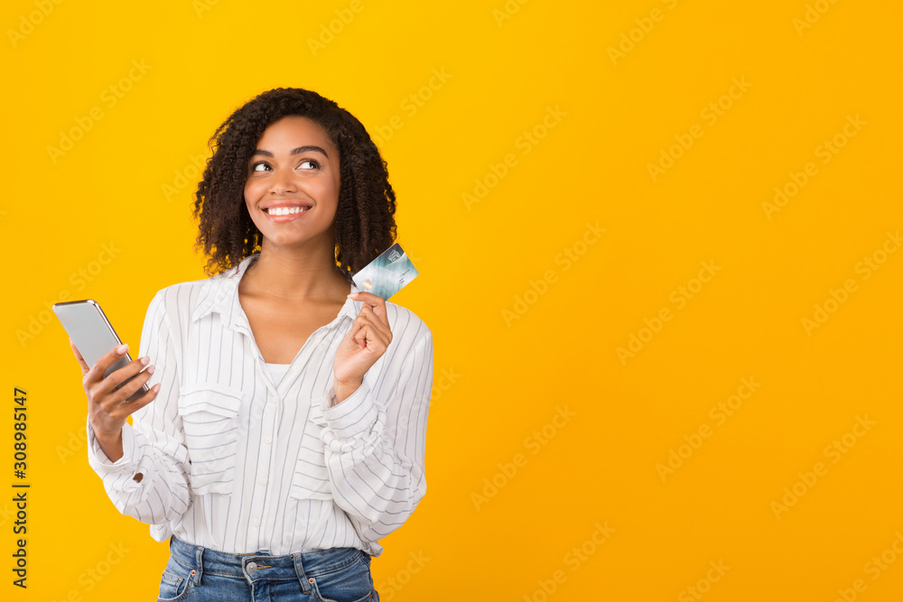 African american girl holding credit card and smartphone African american girl holding credit card and smartphone