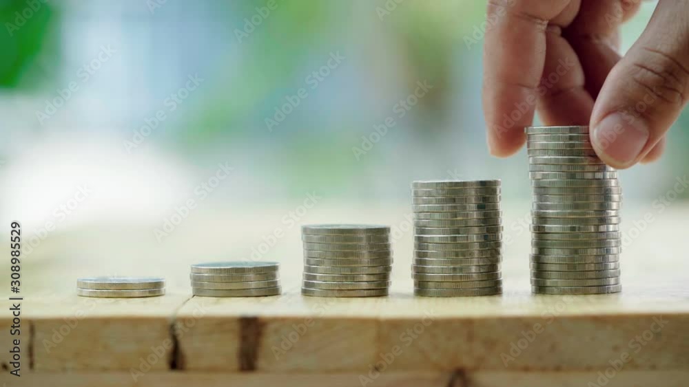 Businessman insert coins into stack coin. Saving money and business finance growth concept