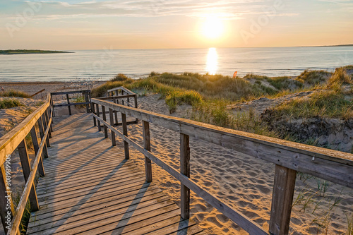 Wooden path at Baltic sea over sand dunes with ocean view  sunset summer evening