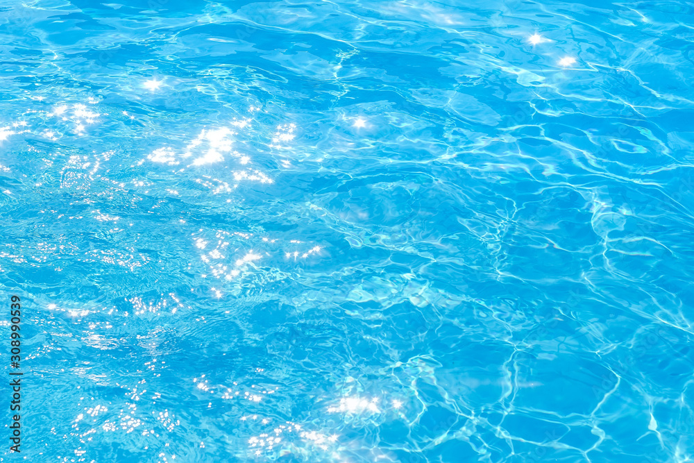 surface of blue swimming pool,background of water in swimming pool. texture, blue water, bright rays of the sun