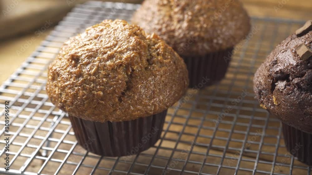 An assortment of muffins cooling on a rack. An assortment of muffins cooling on a rack.