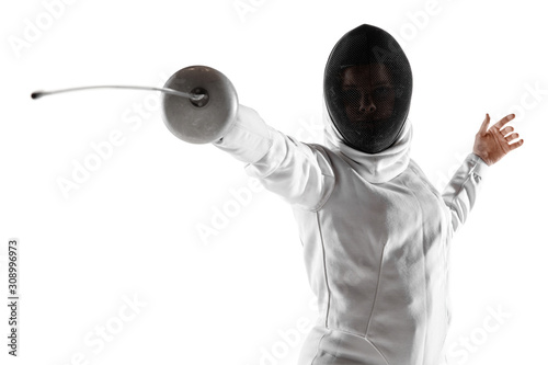Teen girl in fencing costume with sword in hand isolated on white studio background. Young female caucasian model practicing and training in motion, action. Copyspace. Sport, youth, healthy lifestyle.