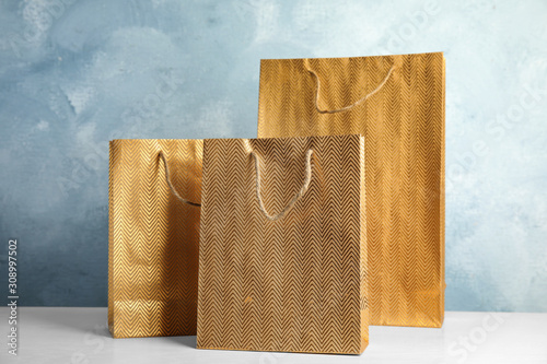 Gold shopping paper bags on white table