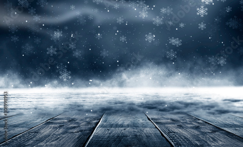 Winter background. Winter snow landscape with wooden table in front. Dark winter forest background at night. Snow, fog, moonlight. Dark neon night background in the forest with moonlight. © MiaStendal