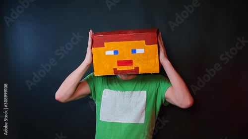 A man brings his hands to a drawn mask on his head. photo