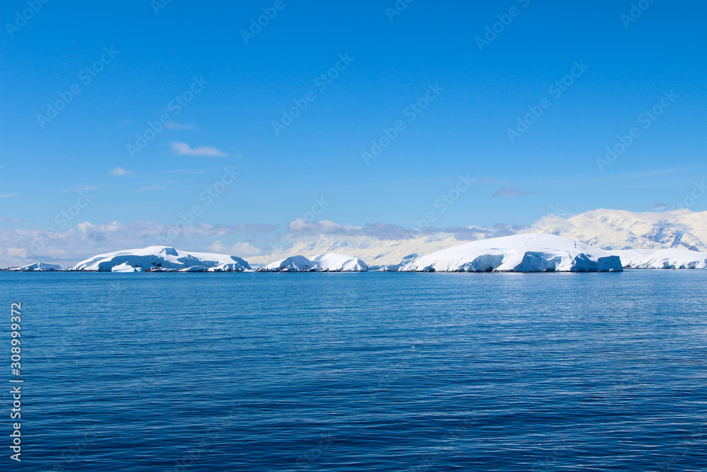 Snow-capped mountains on an island along the coasts of the Antarctic Peninsula, Antarctica