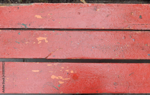 old shabby red painted park bench boards