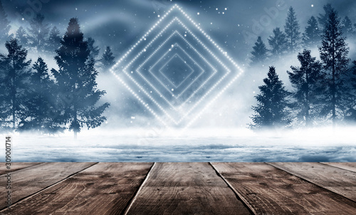 Winter background. Winter snow landscape with wooden table in front. Dark winter forest background at night. Snow, fog, moonlight. Dark neon night background in the forest with moonlight. © MiaStendal