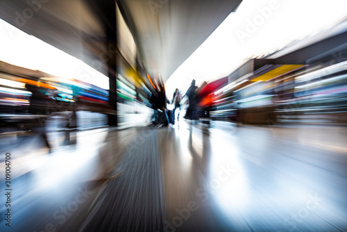 people in the station as they walk fast, blurred photo