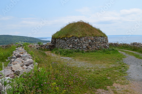 Fototapeta Summer in Nova Scotia: Highland Scot Blackhouse of Stone and Sod in Iona on Cape
