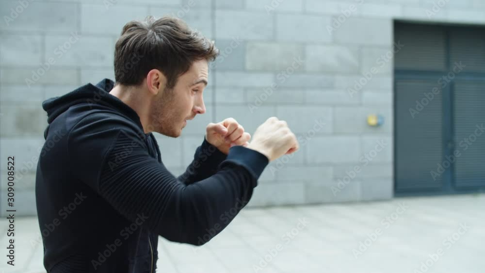 Close up athlete man boxing with fist outdoor. Male fighter training box punch Close up athlete man boxing with fist outdoor. Male fighter training box punch