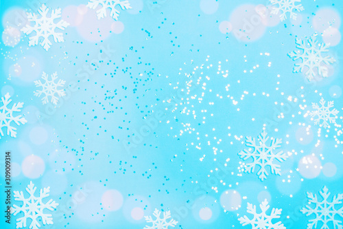 Blue snowflakes and sparkles on a blue background. Christmas background in color of the year 2020 concept