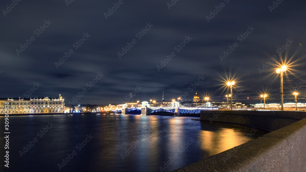 Fototapeta premium Panorama of the night city Saint Petersburg before Christmas. Neva River, Palace Bridge, St. Isaac's Cathedral and the building of the Winter Palace in festive night illumination
