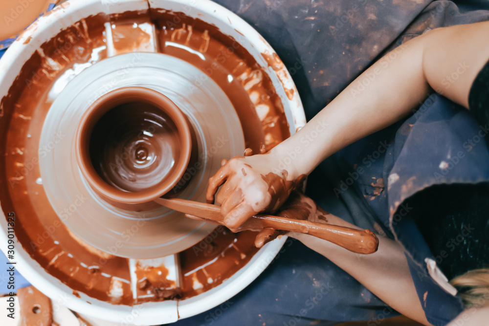 Fototapeta premium Potter gives final shape to clay product