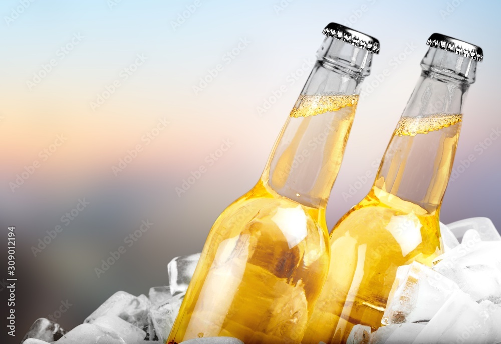 Bottles of cold and fresh beer with ice on background Bottles of cold and fresh beer with ice on background