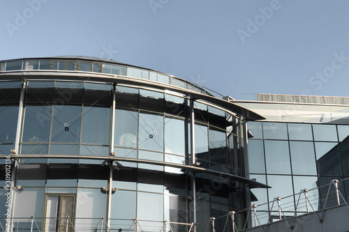 Modern city building facade with iron ceilings and mirrored windows on the background of clear blue sky. modern office building in central of Kyiv, low angle view.