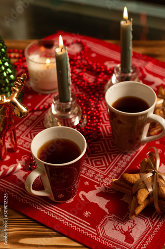 Top view of cups of black tea with Christmas decoration and gingerbread cookies