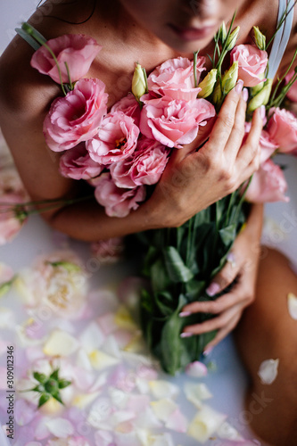 Beautiful girl in the bathroom with many flowers.