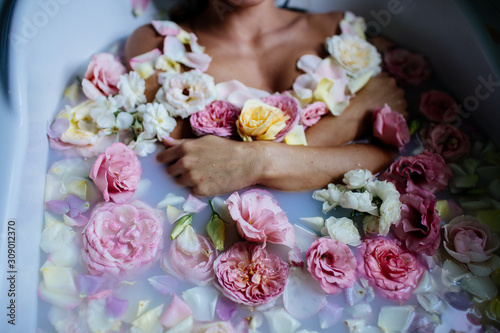 Beautiful girl in the bathroom with many flowers.