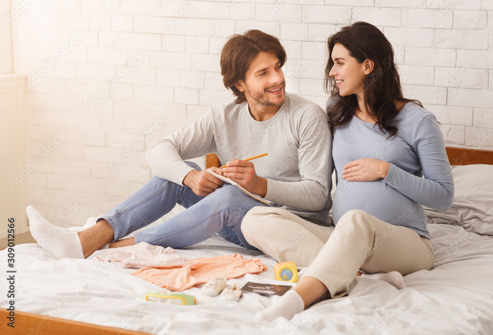 Pregnant couple making checklist before going to maternity hospital Pregnant couple making checklist before going to maternity hospital