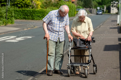 фотографія Elderly Couple with Walking Frame and Stick on the Sidewalk