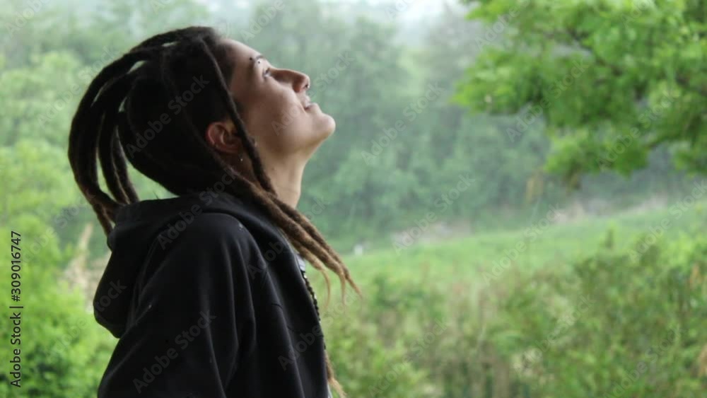 ITALY - SPRING 2018: Girl smile in the rain, close up video of a happy young girl surrounded by the nature during a rainy day. The concept of joy and harmony with nature. ITALY - SPRING 2018: Girl smile in the rain, close up video of a happy young girl surrounded by the nature during a rainy day. The concept of joy and harmony with nature.