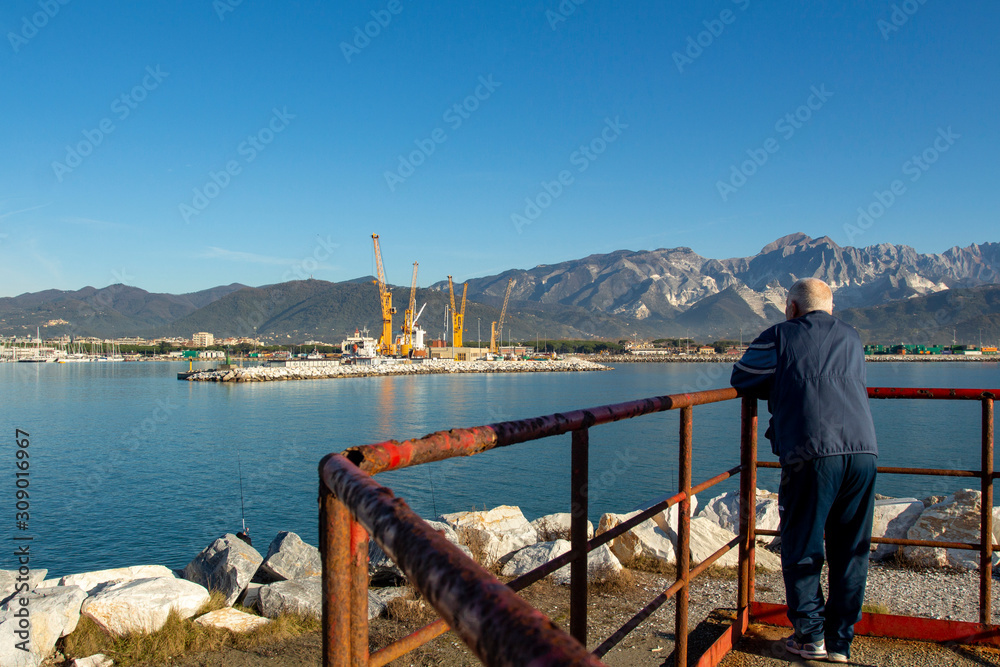 Fototapeta premium Italy, Tuscany: view of the port in Marina di Carrara and in the background the Apuan Alps with the marble quarries