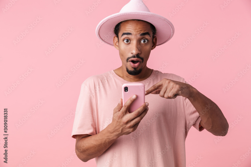 Photo of astonished african american man pointing finger at cellphone Photo of astonished african american man pointing finger at cellphone