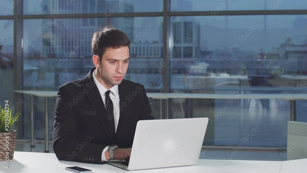 Serious handsome man working using laptop looking in monitor screen. Serious handsome man working using laptop looking in monitor screen.