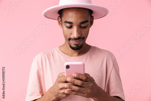Photo of pleased african american man typing on cellphone © Drobot Dean