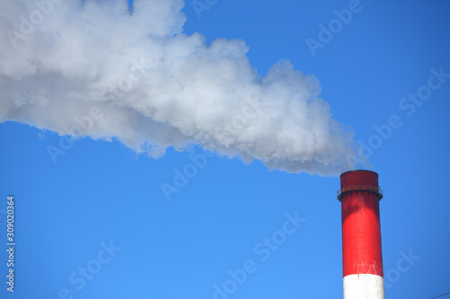 White smoke comes from pipes against blue sky